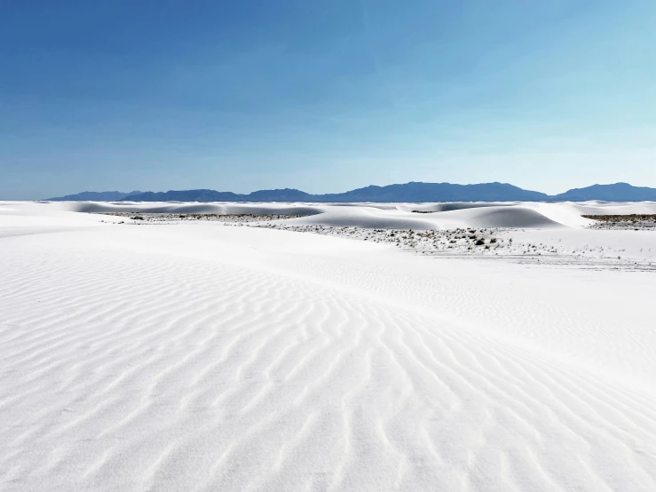 a white snowy area with mountains and sky