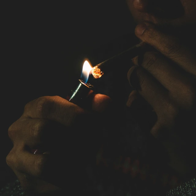 a person is holding a cigarette in the dark