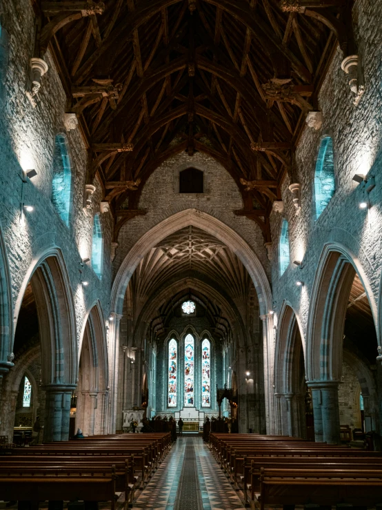 the inside of a church with pews and large stained glass windows