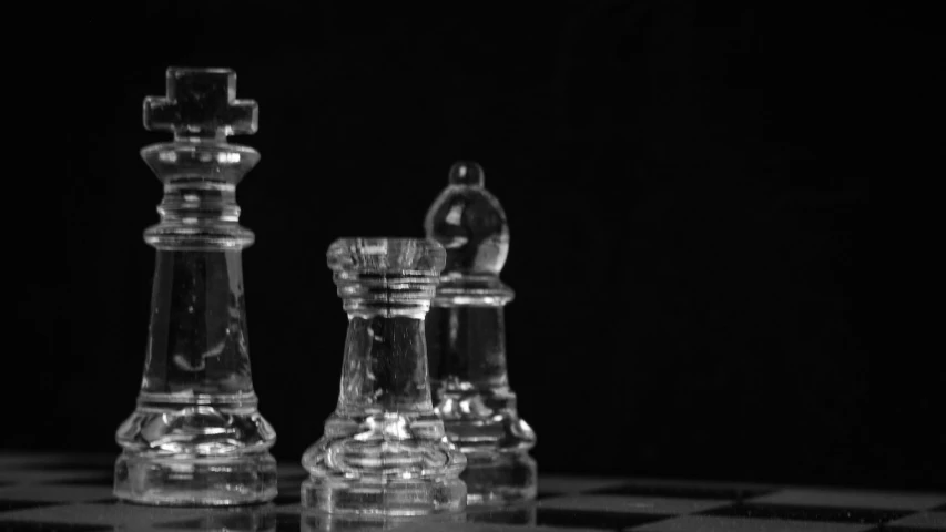 two chess pieces on a chessboard, one chess piece is clear