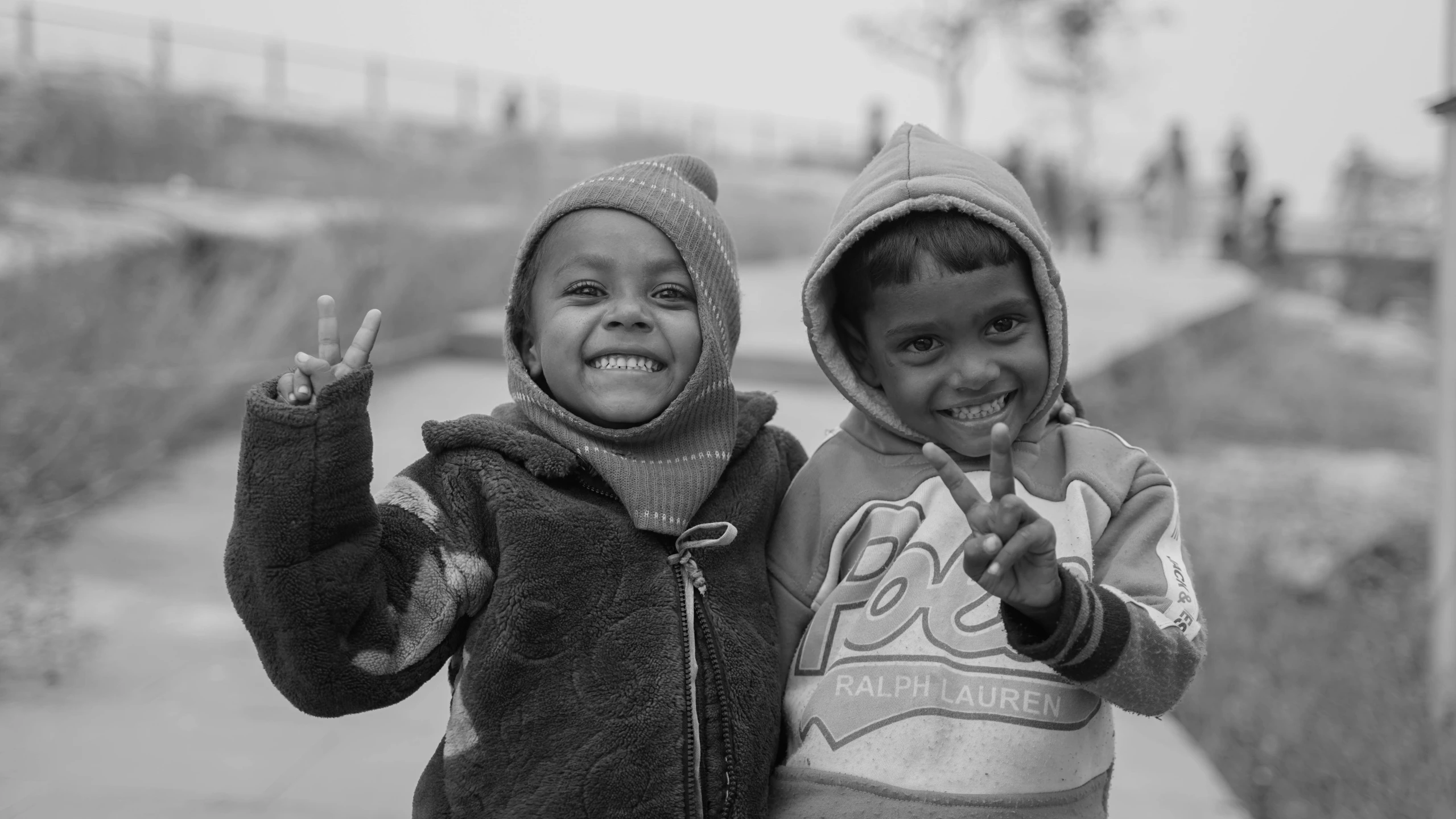 two small children with hoods pose for a picture