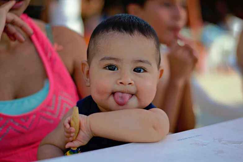 a very cute small child sticking out his tongue