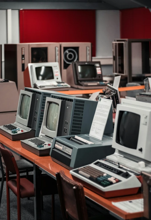 many computer equipment sitting on top of a wooden desk