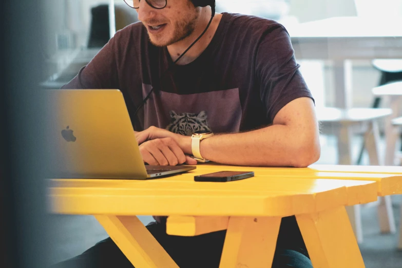 a man with a laptop on his desk in front of a computer screen