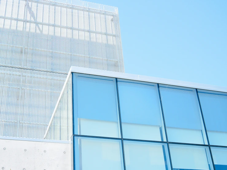 the building is made from glass, with a red stop sign in the middle