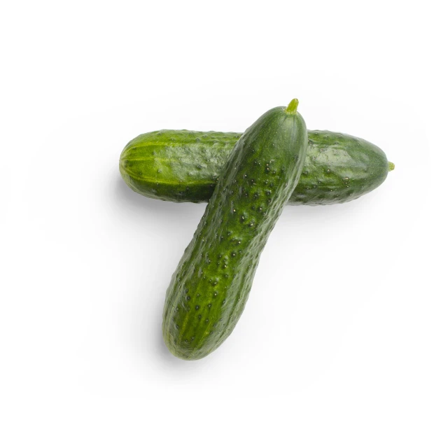 two green pickles sitting side by side on a white surface