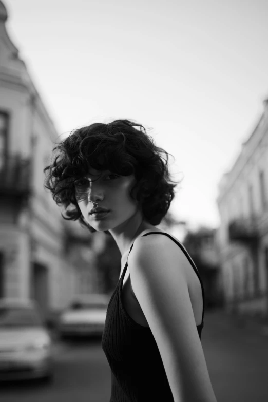 a woman posing in front of buildings with her hand on the hip