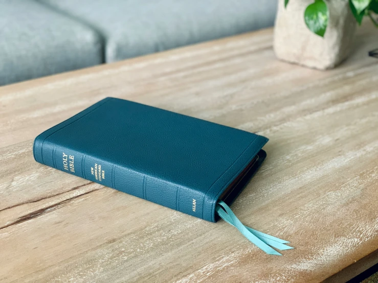a small blue book sitting on top of a wooden table