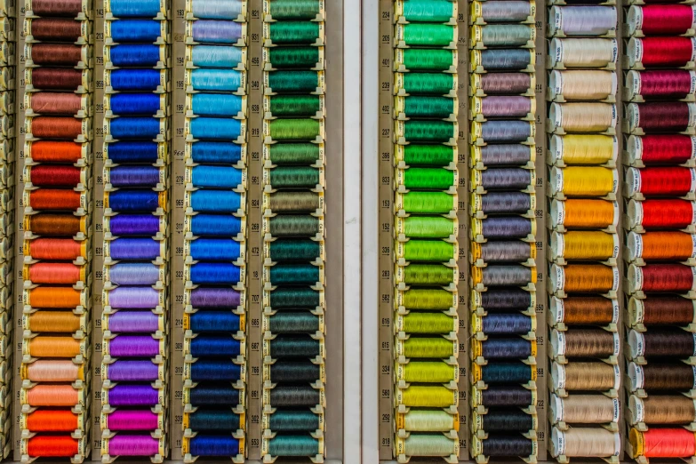 colorful and empty rows of spools of thread