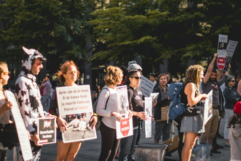 a group of people with protest signs standing next to each other