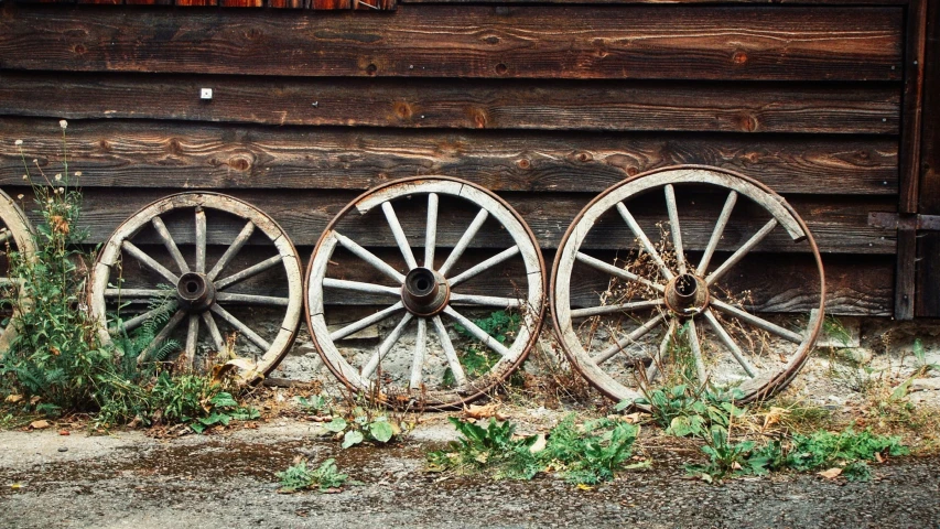 a number of old wagons near a log house