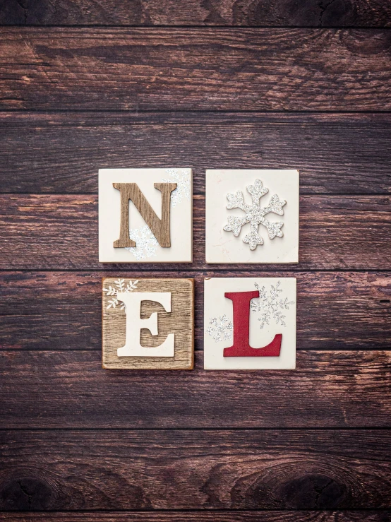 the word noel spelled by wood blocks with decorative patterns