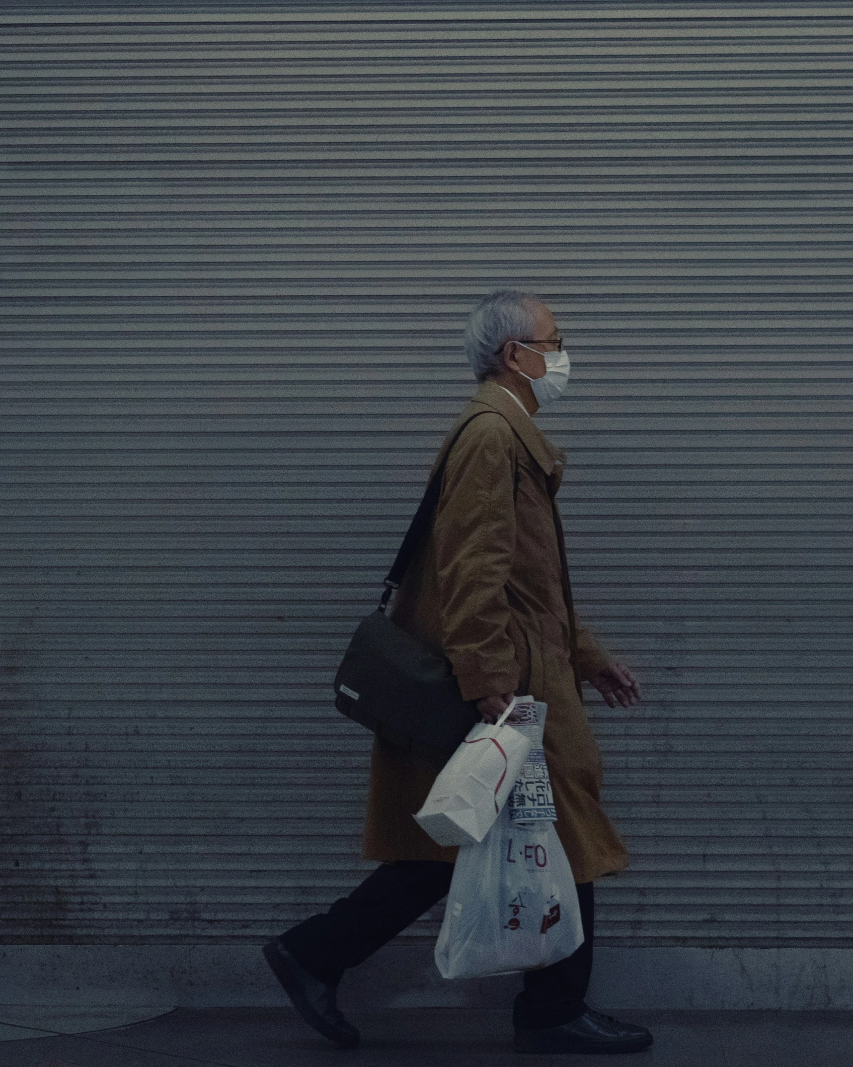 an older man wearing a mask is walking down the street