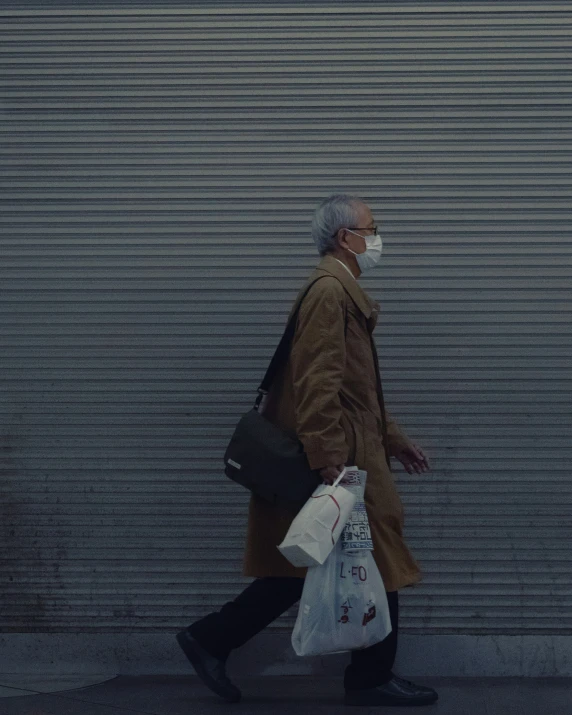 an older man wearing a mask is walking down the street