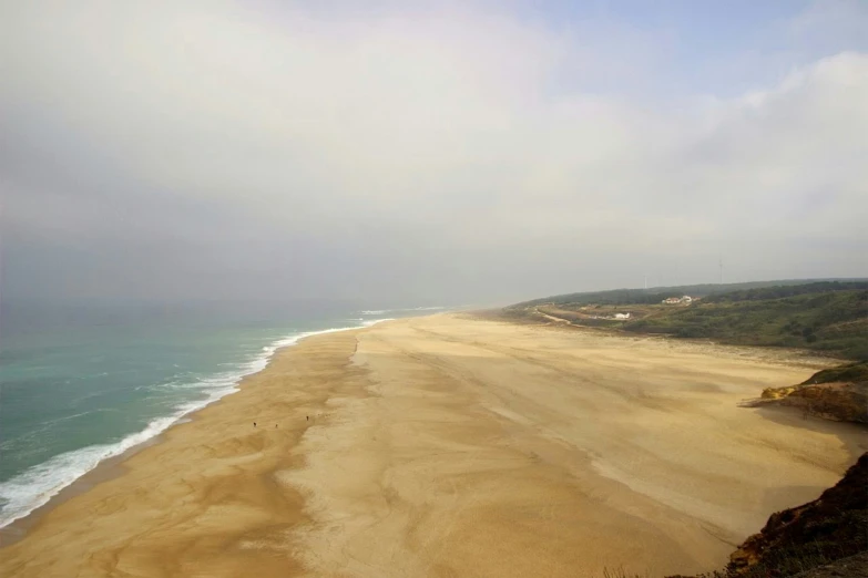 an ocean view with a sandy beach and a cliff