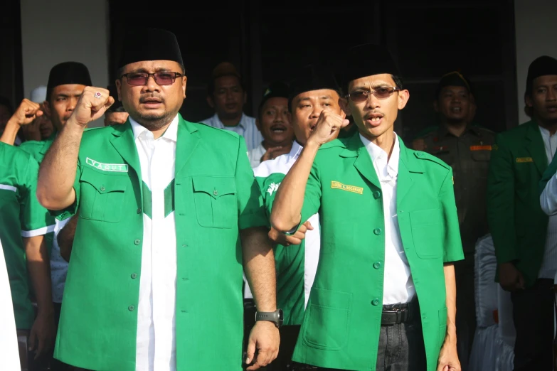 a group of people in green blazers standing together