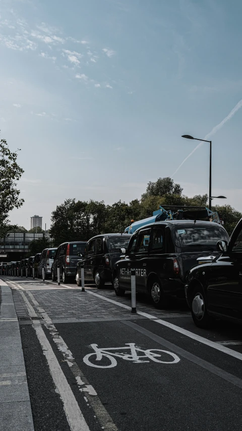 cars are lined up on the side of a busy street