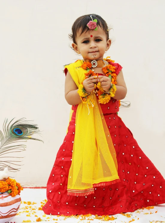 a little girl wearing a flower and garland around her neck