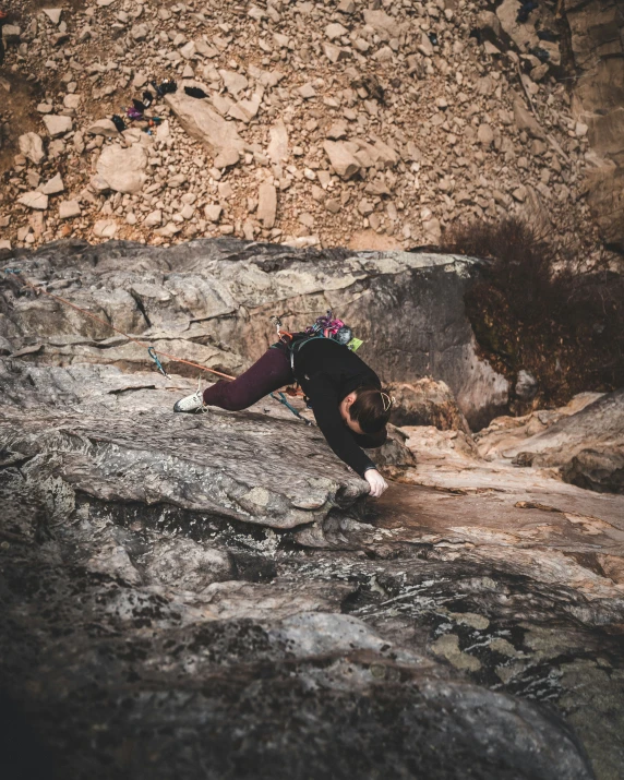 a person on a rock with mountains in the background