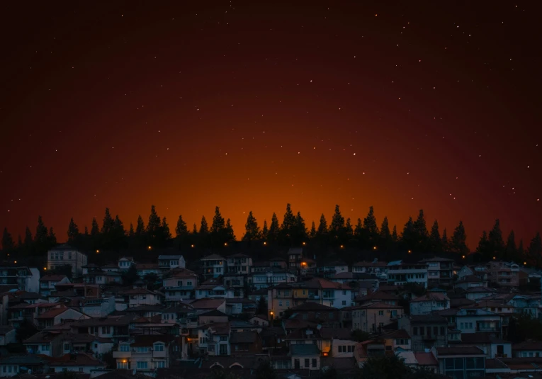 an orange sky at night with stars in the background