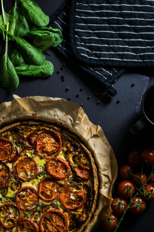 a pizza is on a table with tomatoes