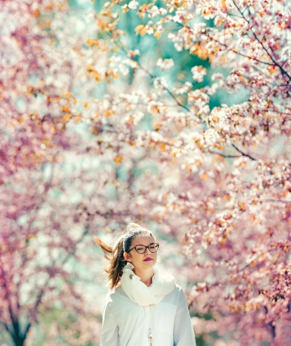 a woman is walking down the sidewalk between trees