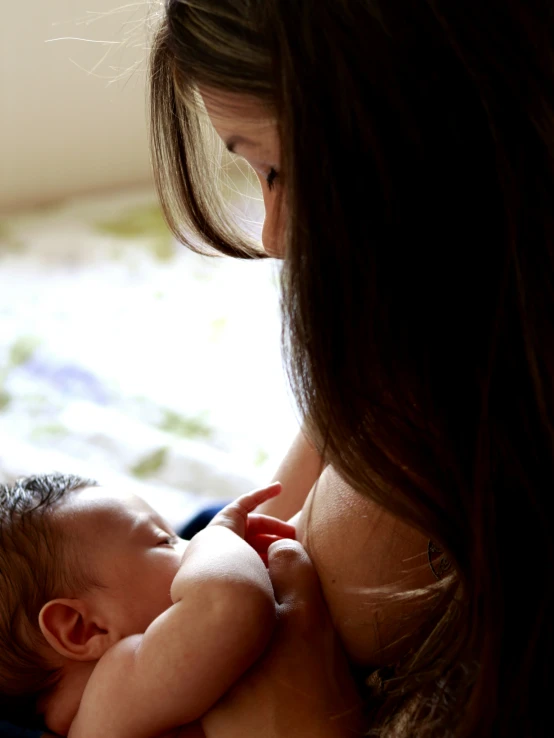 a woman is holding her baby in her arms