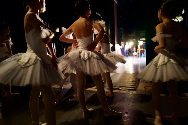 a group of dancers wearing tutus in the middle of a dance floor