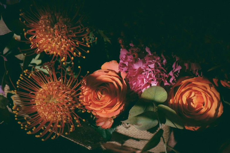 a bouquet of orange and pink flowers is displayed