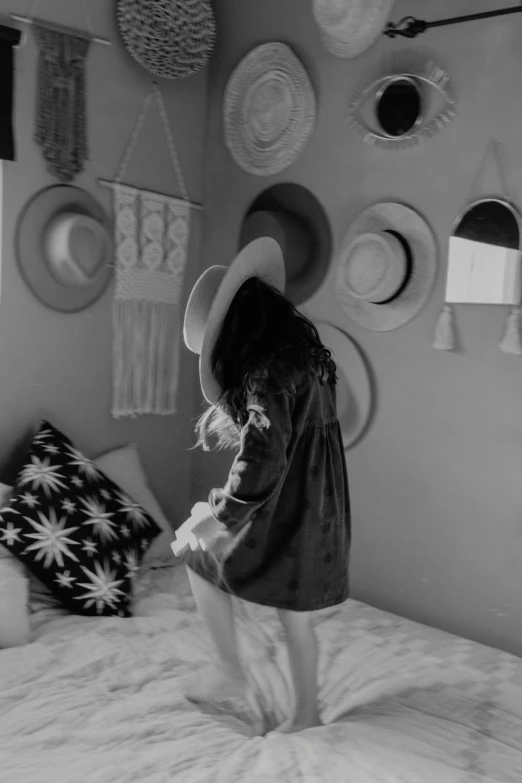 a girl with long hair in a hat on a bed