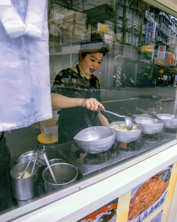 a person in a kitchen cooking food in a pan