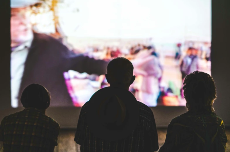 a group of people watch an image on the screen