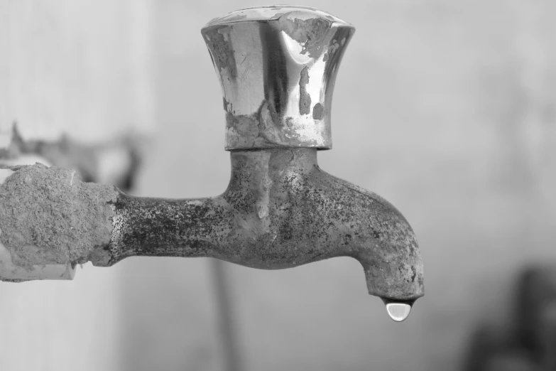 a dirty water faucet leaking from it's handle