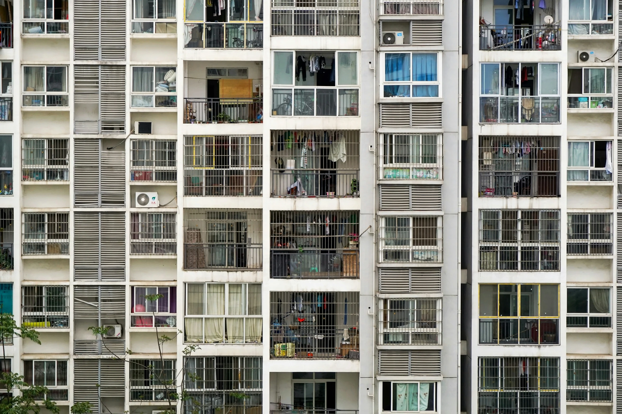 an artistic architectural po taken at daytime of a tall building with windows and balconies