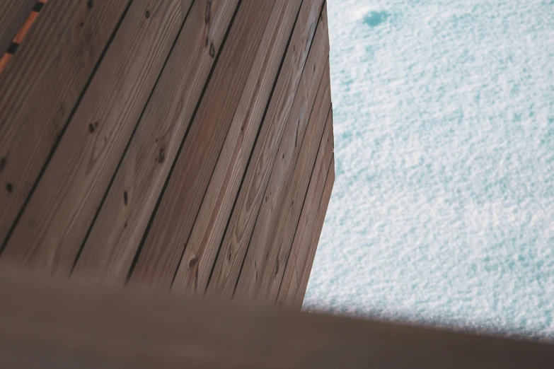 a close up of an angled wooden dock with snow