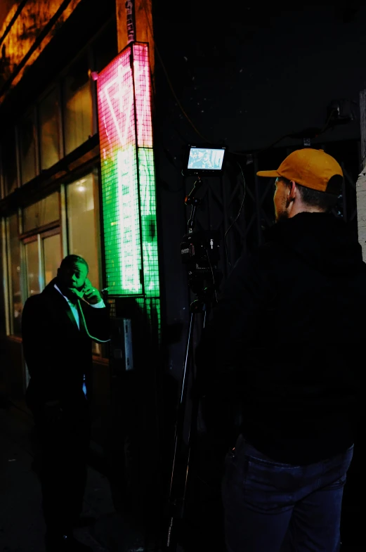 two people near a building that has different colored lights