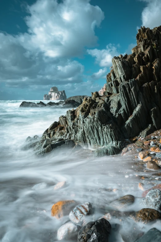 the water looks calm with rock formations in the distance