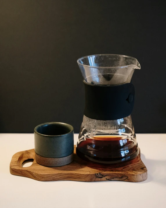 a clear coffee pot and a wooden tray with liquid