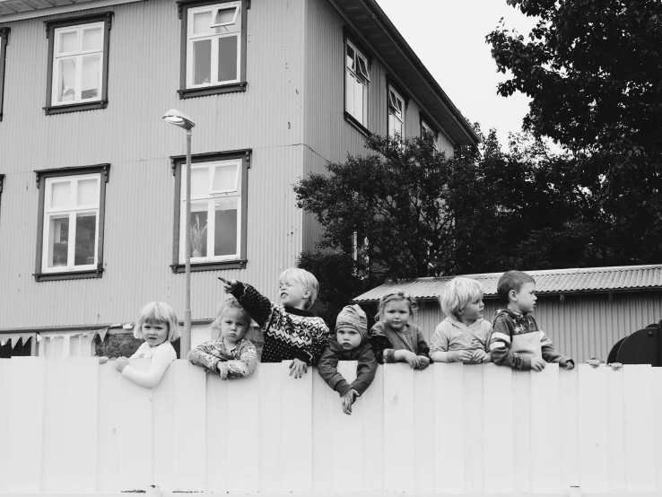 a group of children sitting on a fence