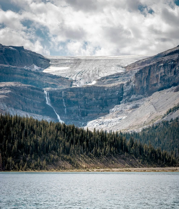 a large mountain on top of a lake with snow