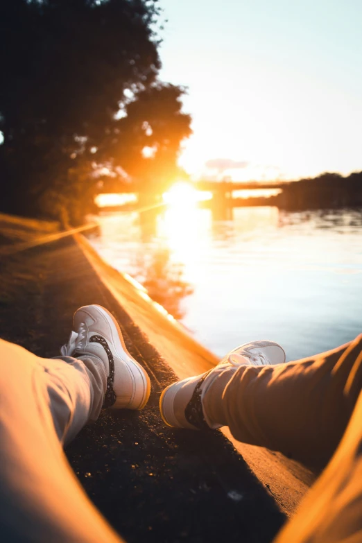 the person sitting on a park bench near a body of water