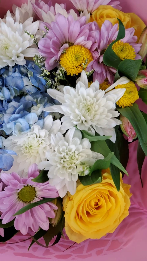 an arrangement of colorful flowers arranged in a flower pot