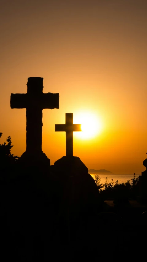 the cross is standing beside a statue in a park