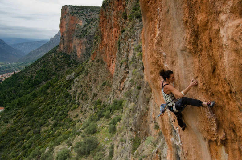 a woman climbing on the side of a mountain