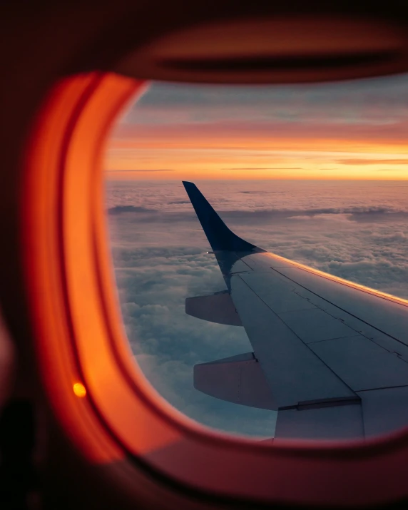 the wing of a plane flying through the clouds