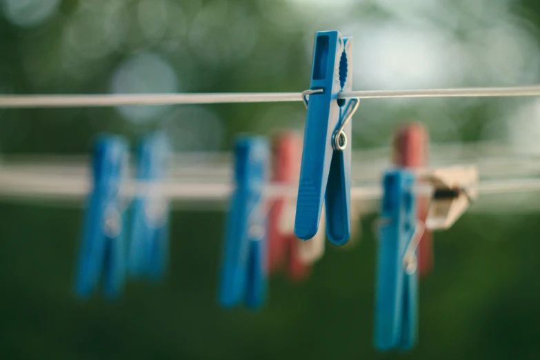 blue pegs are hung on a rope with small clothes pins