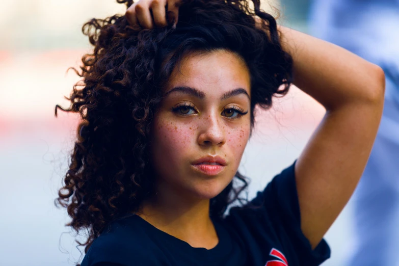 a young woman with black hair is holding her head