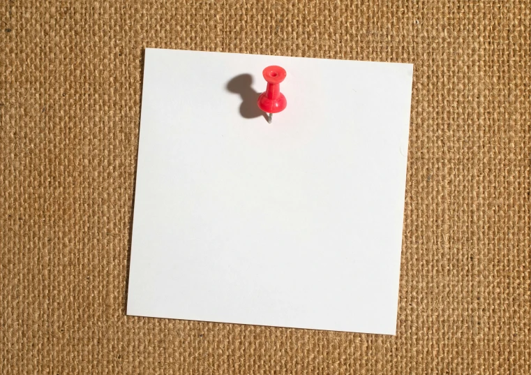 red thumbnail on white paper pinned to a clip