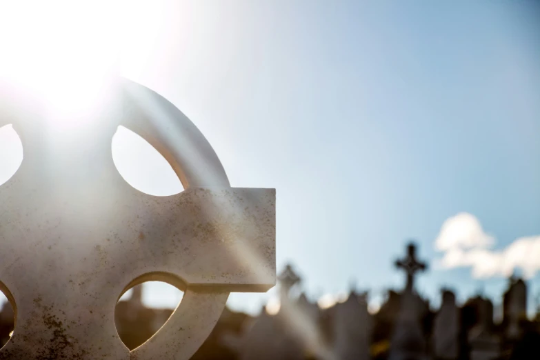 the sun peeks through the lens of a large monument