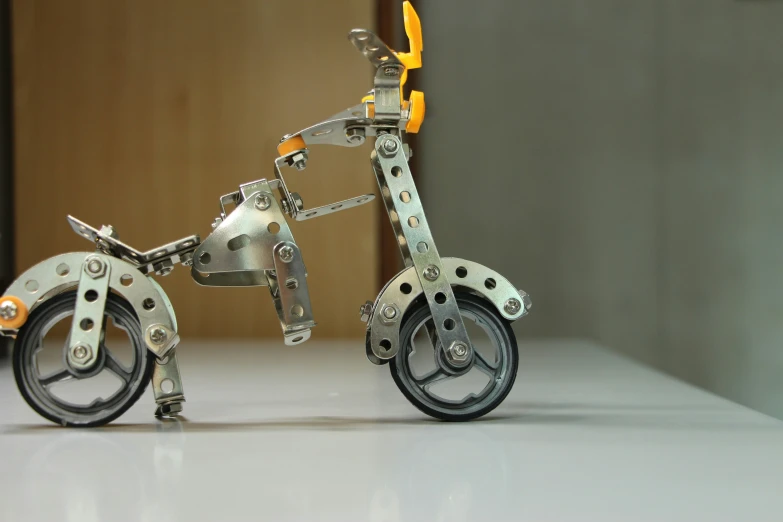 a metal bike with wheels and orange feet